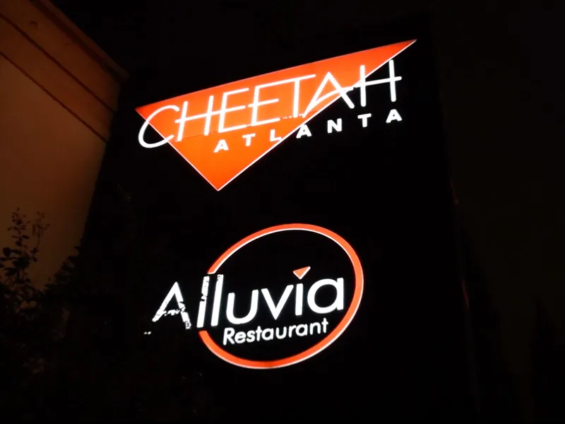 Illuminated Cheetah Atlanta and Alluvia Restaurant sign at night