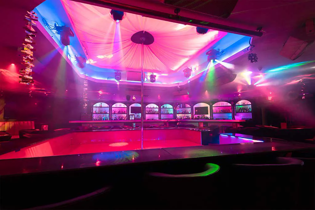 Main room at Bella's Cabaret with the stage, arched back-bar alcoves and coloured lighting