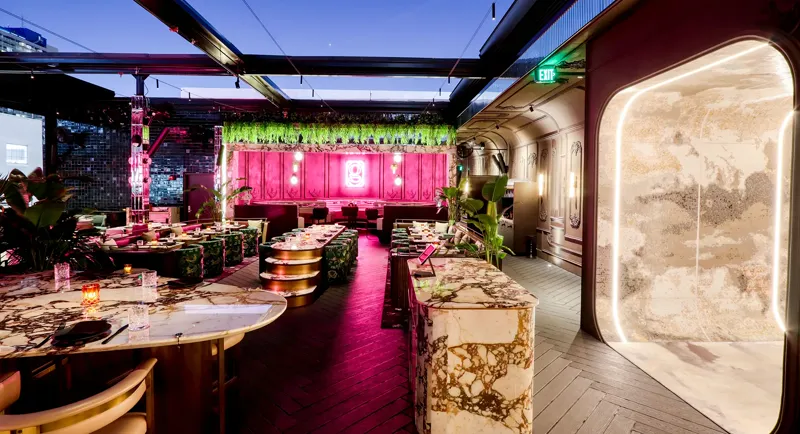 Giselle, the rooftop restaurant at E11EVEN Miami, with marble tables and a pink neon back wall