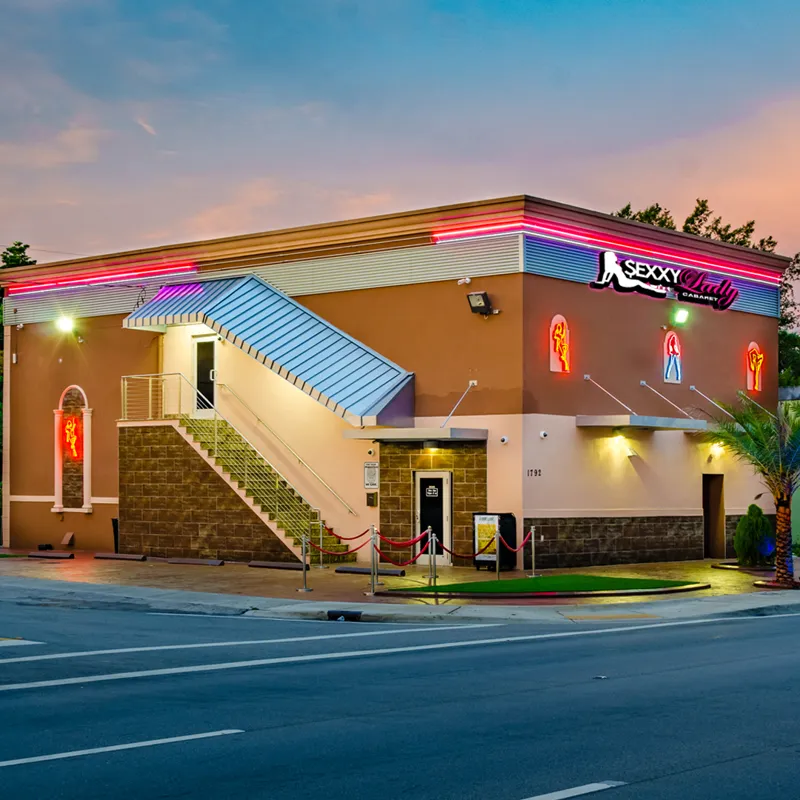 Sexxy Lady Cabaret building exterior at dusk with neon trim and signage