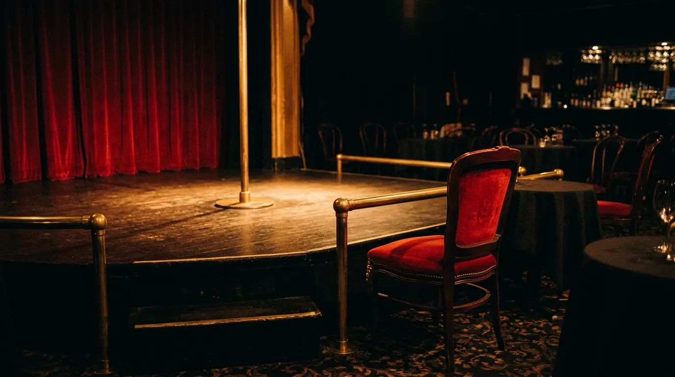 A single front-row chair at the edge of an empty stage